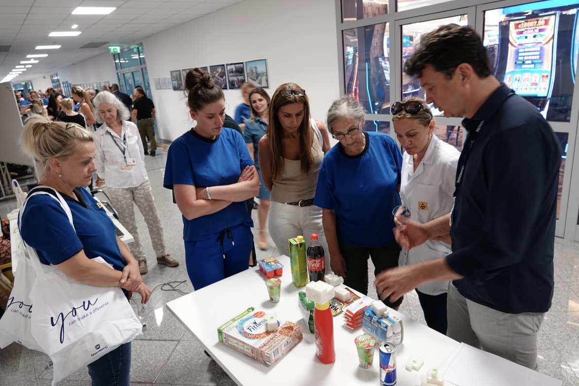 Six NOVOMATIC employees discussing over a table with food products