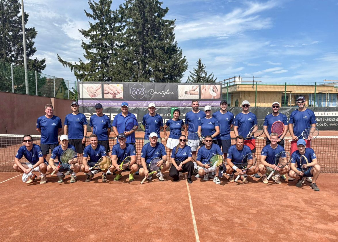 Gruppenfoto NOVOMATIC Mitarbeiter auf Tennisplatz